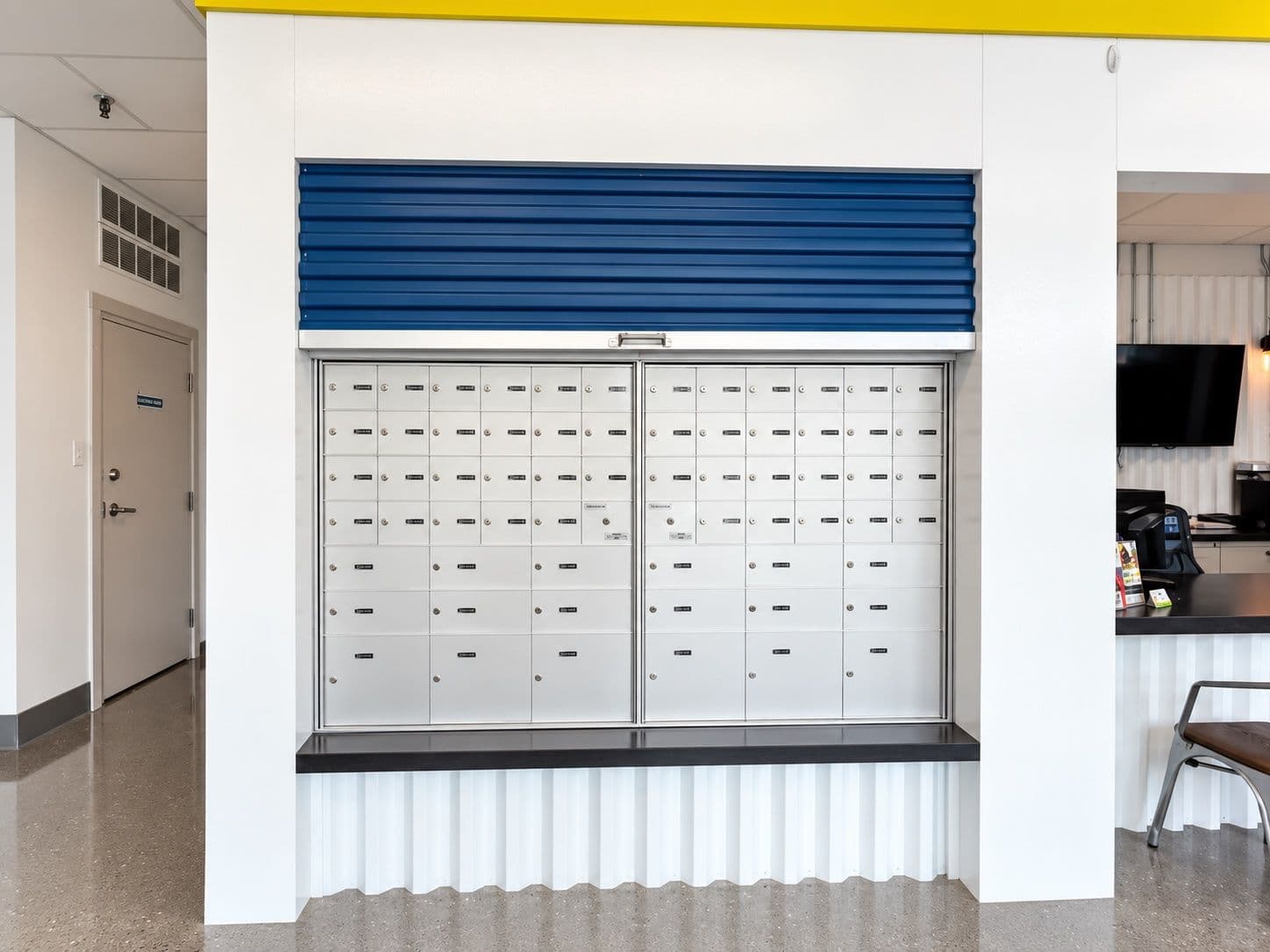 Wall of private mailboxes behind a blue roll-up door at the CityBox Manchester office